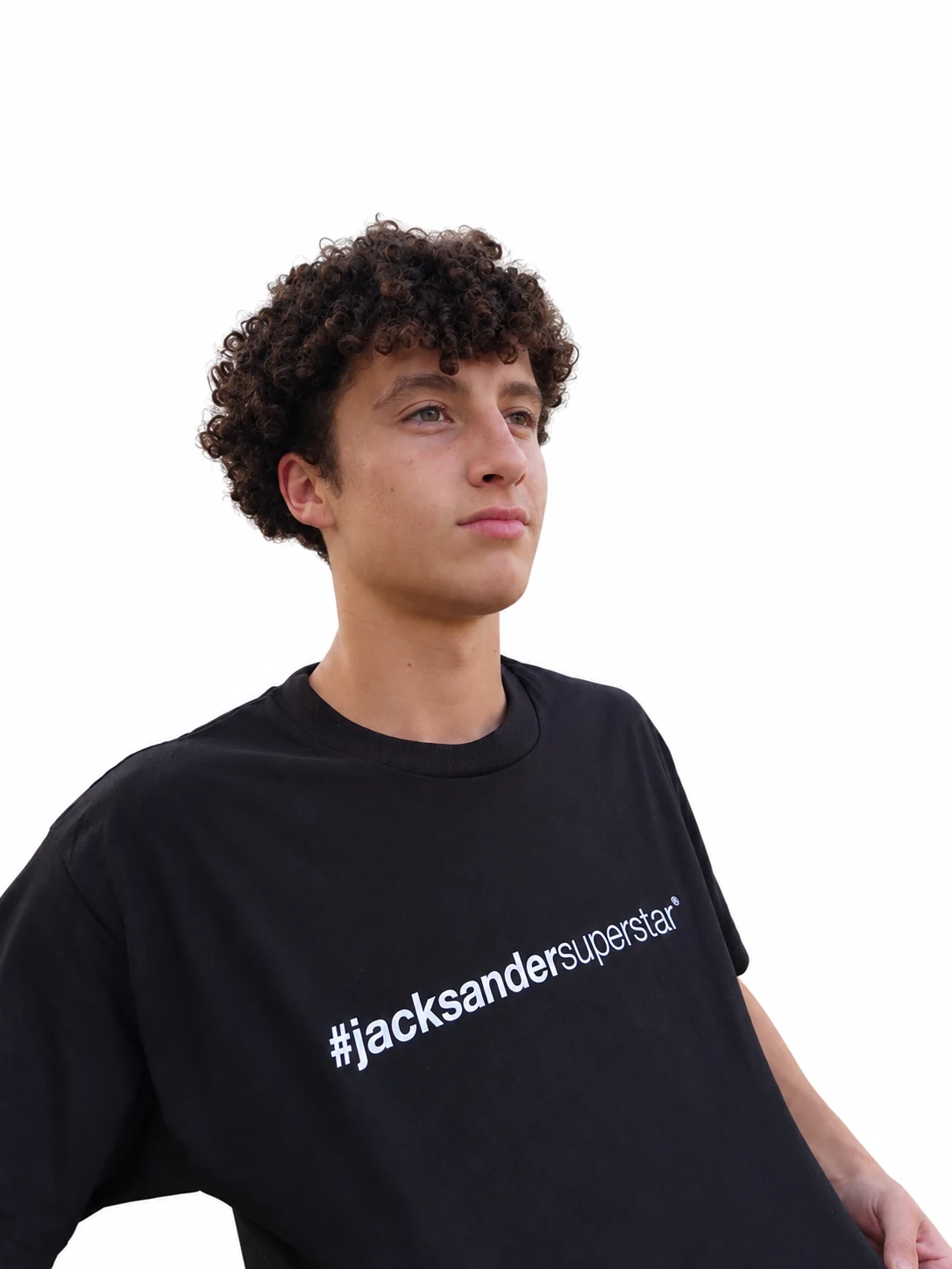 Model in a black jacksandersuperstar tee, holding the shirt hem and looking upward.