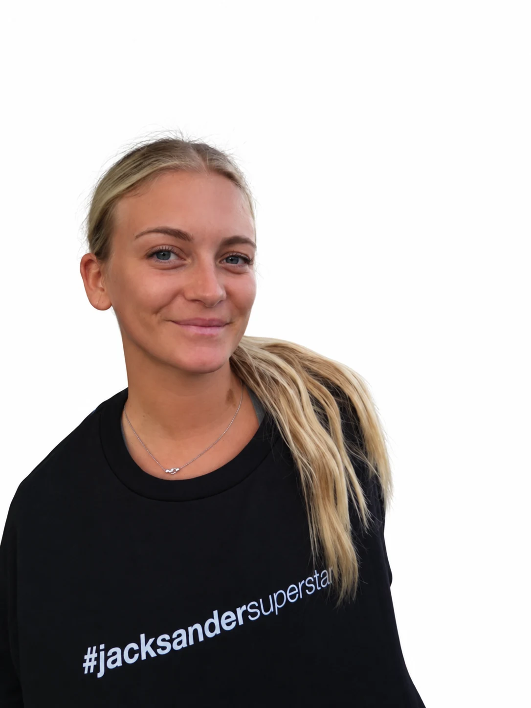 Front portrait of a smiling model with a ponytail and necklace wearing a black jacksandersuperstar tee.